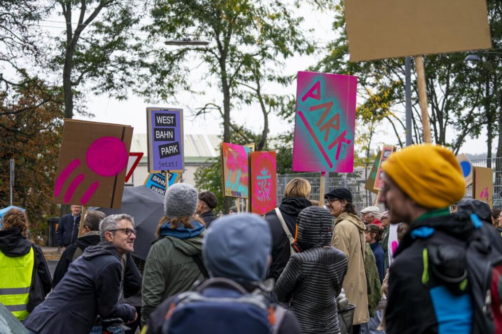Bild von einer Menschenmasse mit Schildern für den Westbahnpark