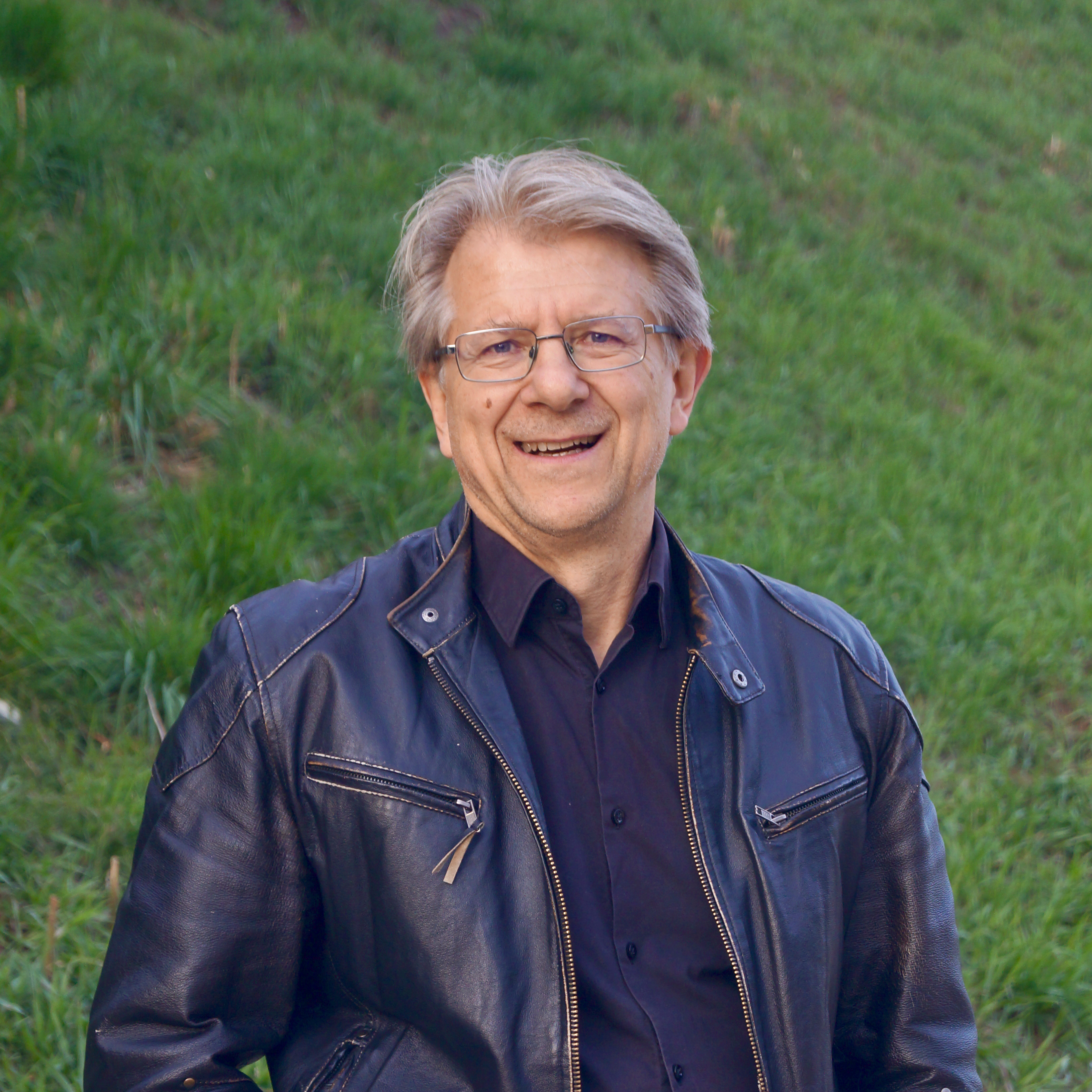 Portraitfoto von Christian Höfer. Im Hintergrund die Biodiverse Böschung am Westbahnhof-Areal.